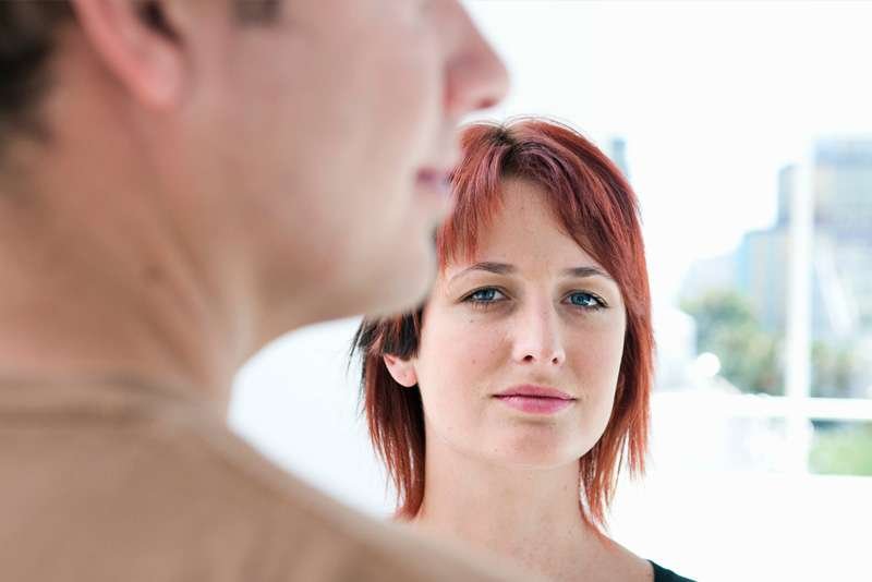 Two people in conversation, woman in focus.